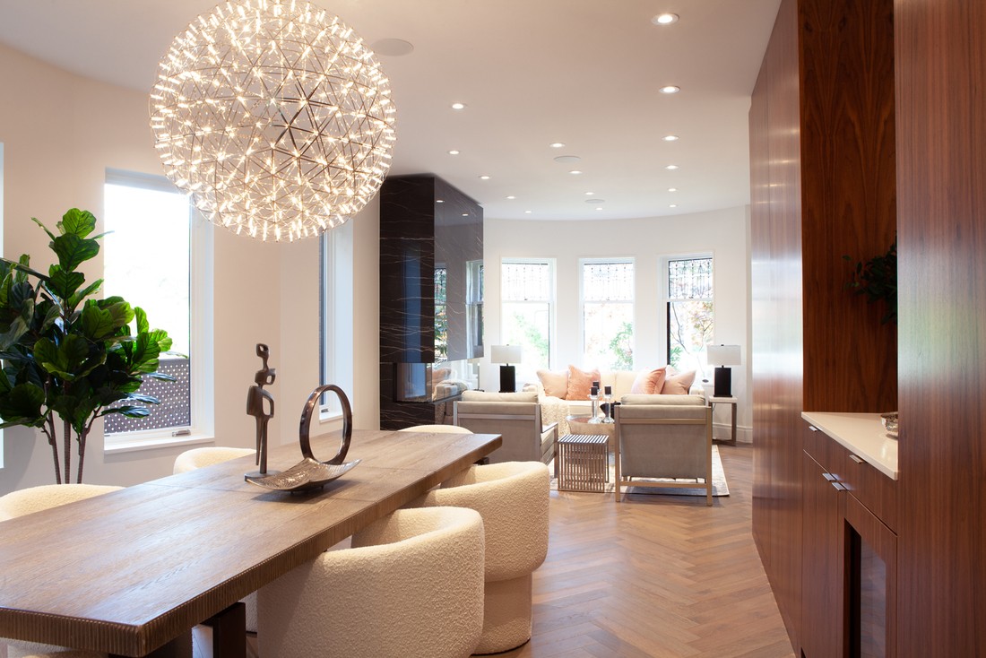 Dining room and view of living room with hanging spherical chandelier above table in Rosedale, Toronto custom home