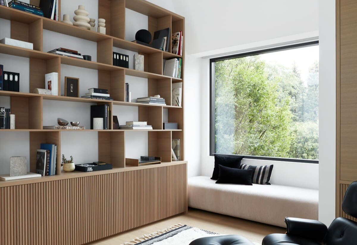 Chair and rug in front of custom-built bookshelf in office of Toronto custom home by SevernWoods